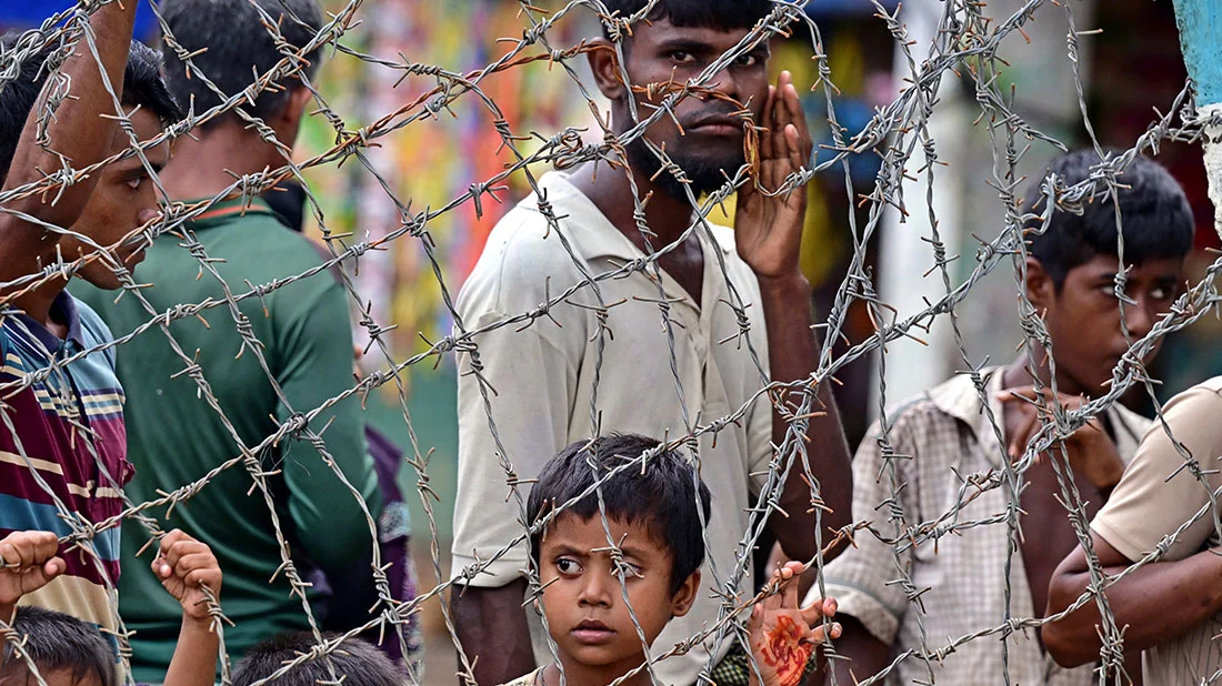 File image: Rohingya refugees stand behind barbed wires at Kutupalong refugee camp on September 9, 2024. Photo: AFP